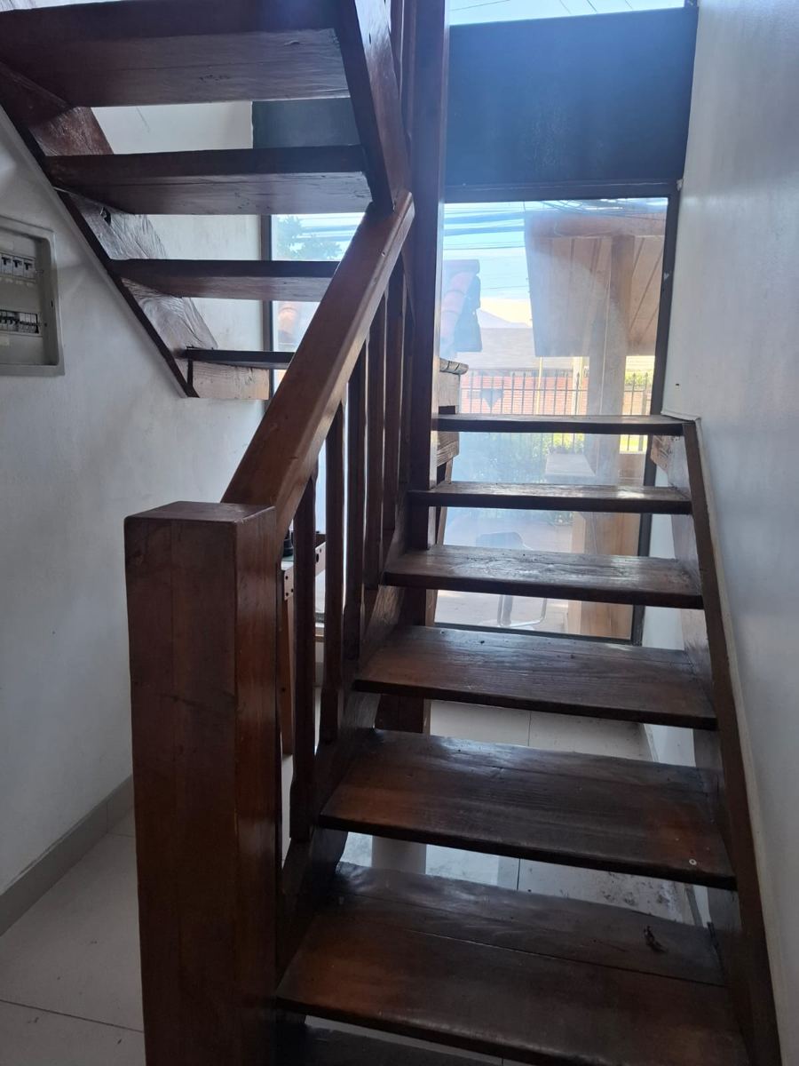 Escalera de madera con baranda, recuperada de una demolición de SG Ingeniería y Demoliciones en Santiago