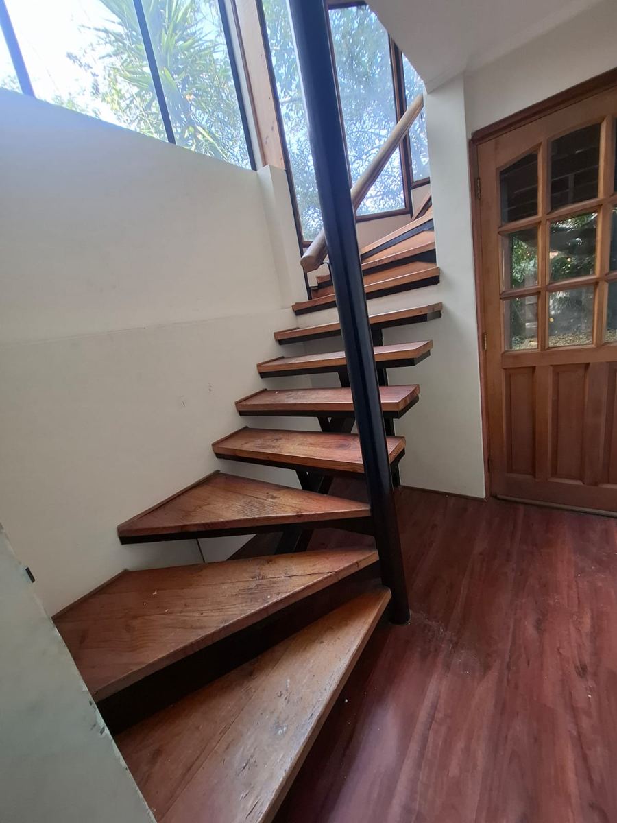 Escalera de madera de peldaños abiertos, recuperada de una demolición de SG Ingeniería y Demoliciones en Santiago