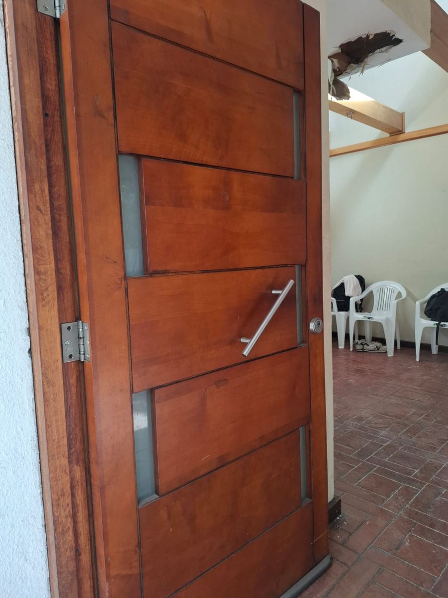 Puerta de madera maciza con vidrios verticales, recuperada de una demolición de SG Ingeniería y Demoliciones en Santiago
