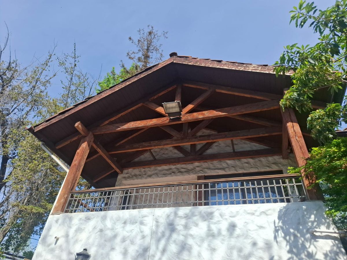 Techo de terraza con cerchas de madera y baranda de fierro, recuperada de una demolición de SG Ingeniería y Demoliciones en Santiago
